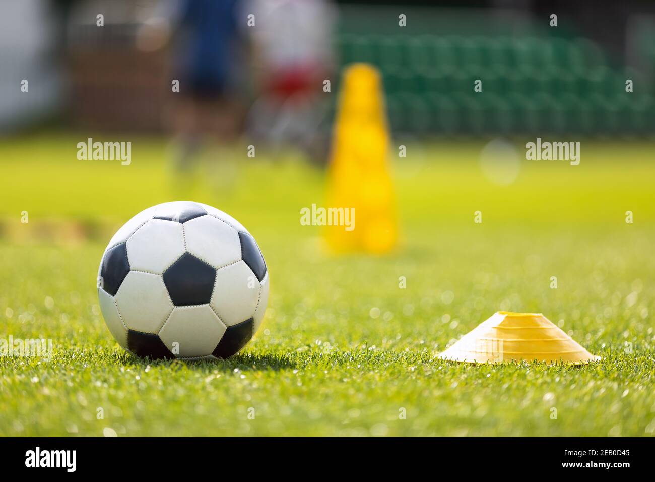 Soccer Ball and Yellow Cone Marker on Training Pitch. Football Turf. Soccer Stadium in Blurred