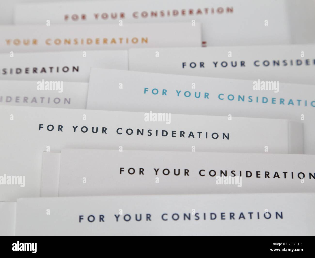 A pile of DVD movie and TV show screener jackets displaying “FOR YOUR CONSIDERATION” is shown up close. Stock Photo