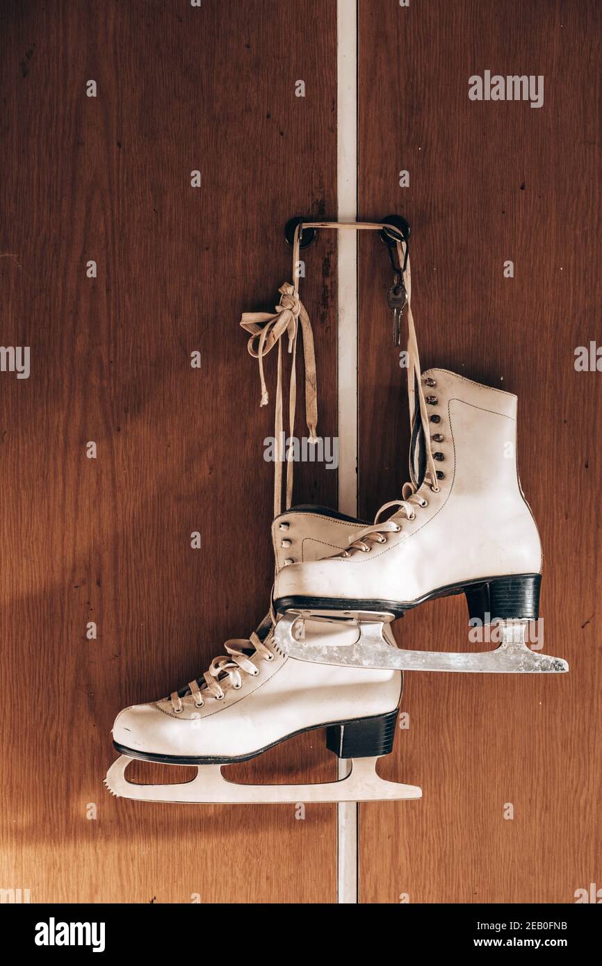 Old retro skates hanging on the wall Stock Photo