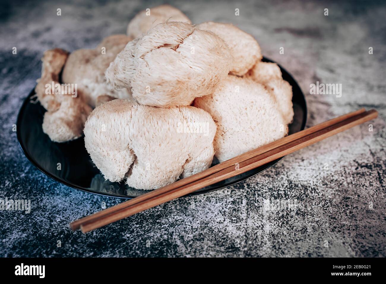 Hericium erinaceus or Lion's mane mushrooms on a plate with Chinese sticks. Medical mushroom concept Stock Photo