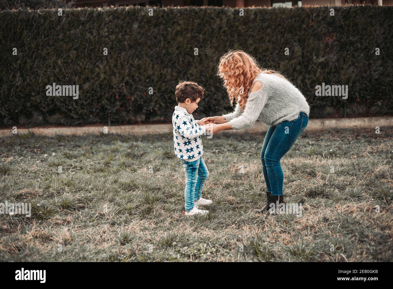 Mom playing with her kid son in the park Stock Photo