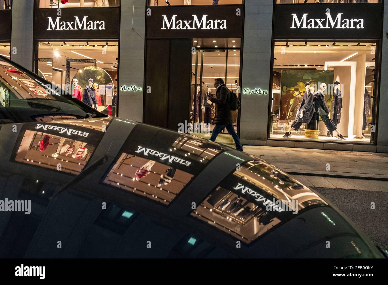 London, UK. 10th Feb, 2021. A man walking past the Max Mara in New Bond  Street in London, during the third nationwide lockdown.Max Mara is a  up-market ready-to-wear Italian fashion company. It