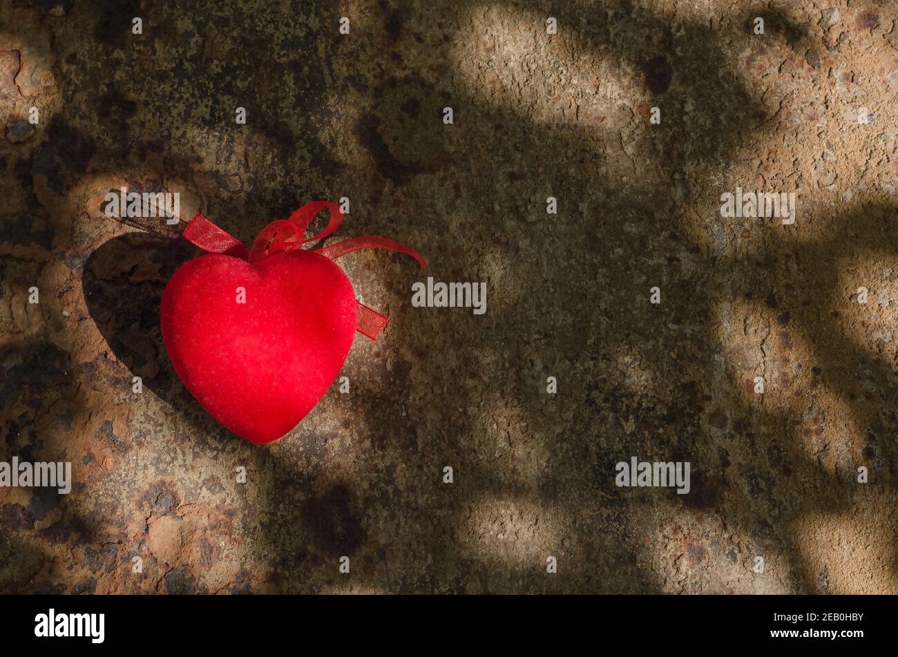 Valentine's day background, red heart on rust background with sunbeams ...