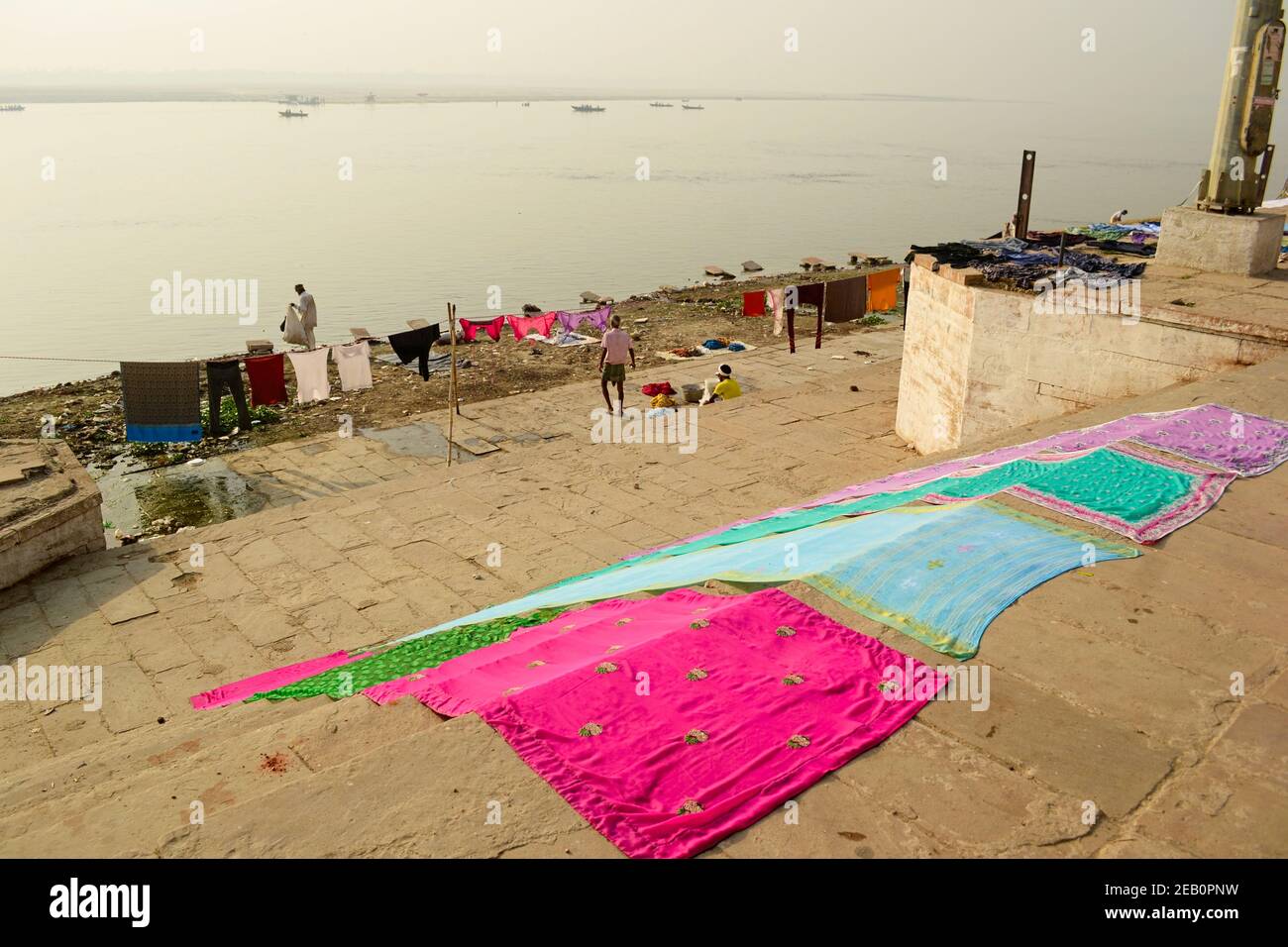 Varanasi, India - April, 2014: Drying clothes on the ghats along Ganges. Colorful saree drying on the floor. Outdoor hand wash laundry. Stock Photo