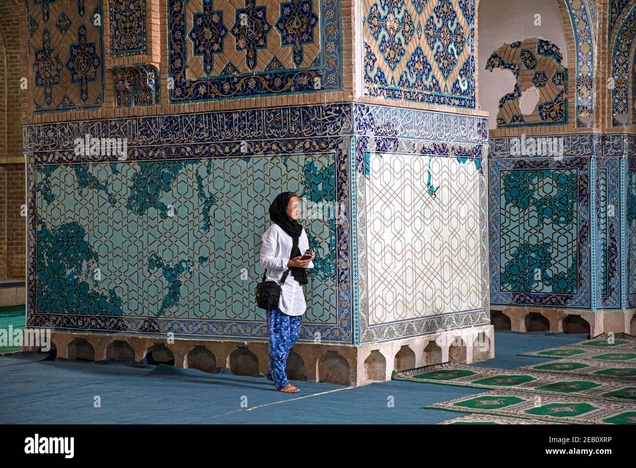 Respectful Western female tourist wearing headscarf visiting the 15th century Blue Mosque / Masjed-e Kabūd in Tabriz, East Azerbaijan Province, Iran Stock Photo
