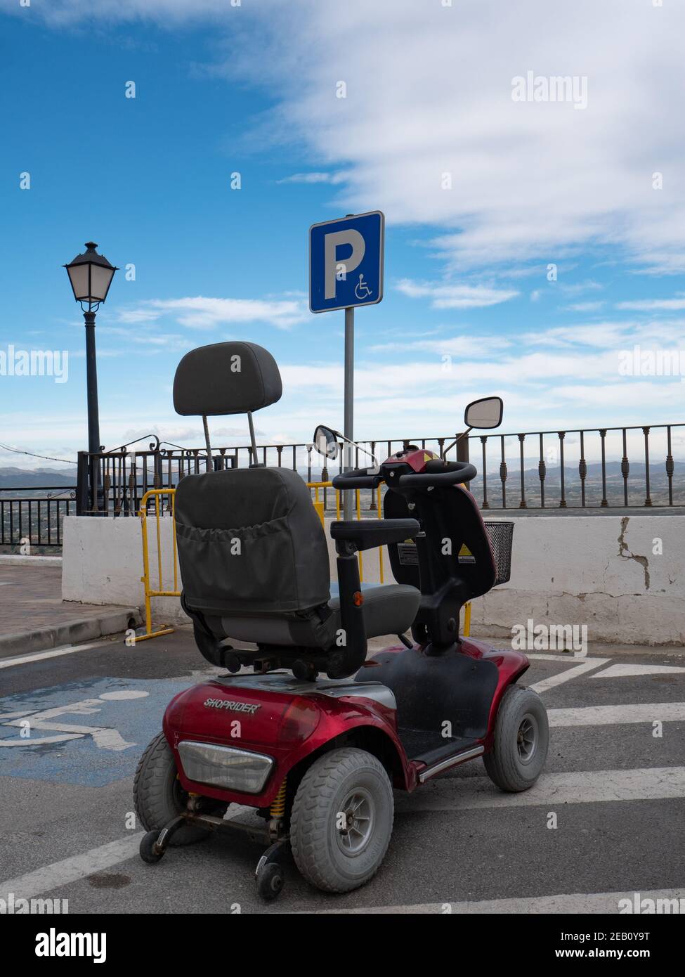 Invalid mobility scooter parked in a parking bay Spain. Stock Photo