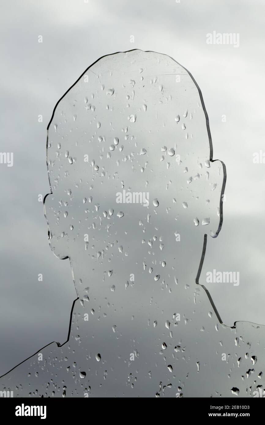 Transparent plastic in shape of human head covered in rain drops Stock Photo