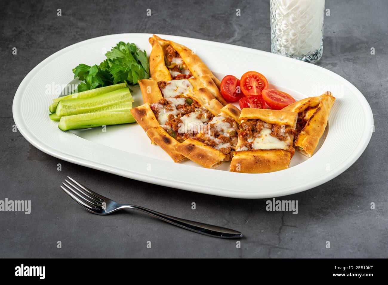 Sliced ​​minced meat pita with buttermilk and salad on stone table. Stock Photo
