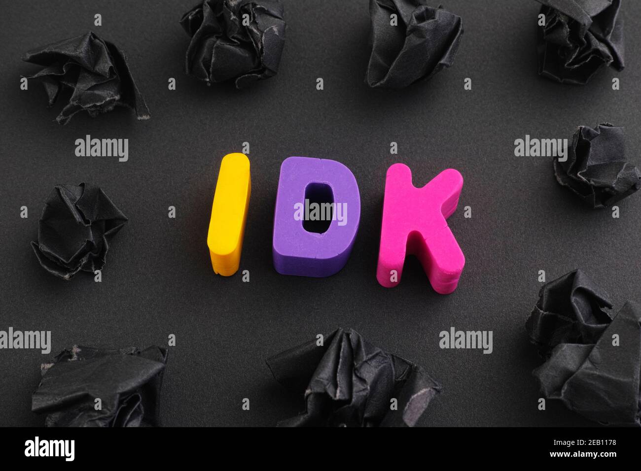 The abbreviation IDK (I don't know) made out of polymer clay letters with  some black crumpled paper balls around it. Low key. Close up Stock Photo -  Alamy