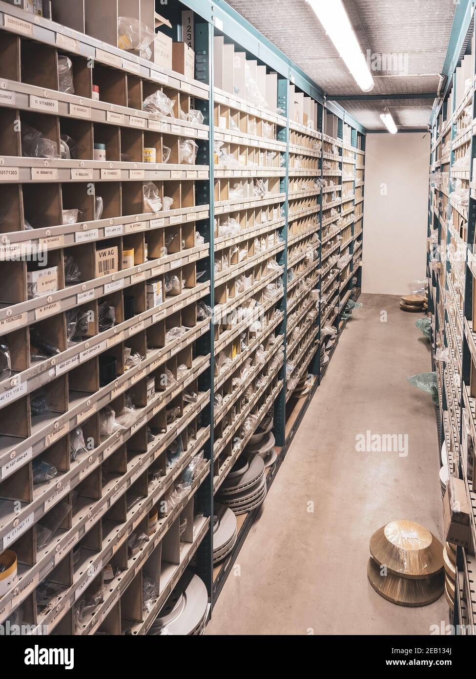 many shelves filled with spare parts stand in the parts store of the