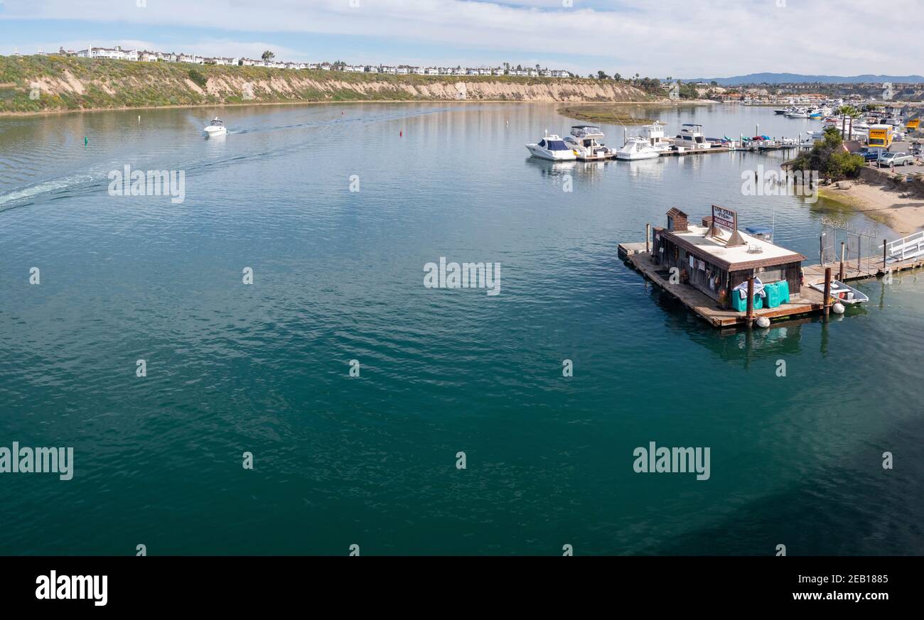 Power yacht with bluff of the Castaways overlooking Back Bay in Newport Beach Southern California USA Stock Photo