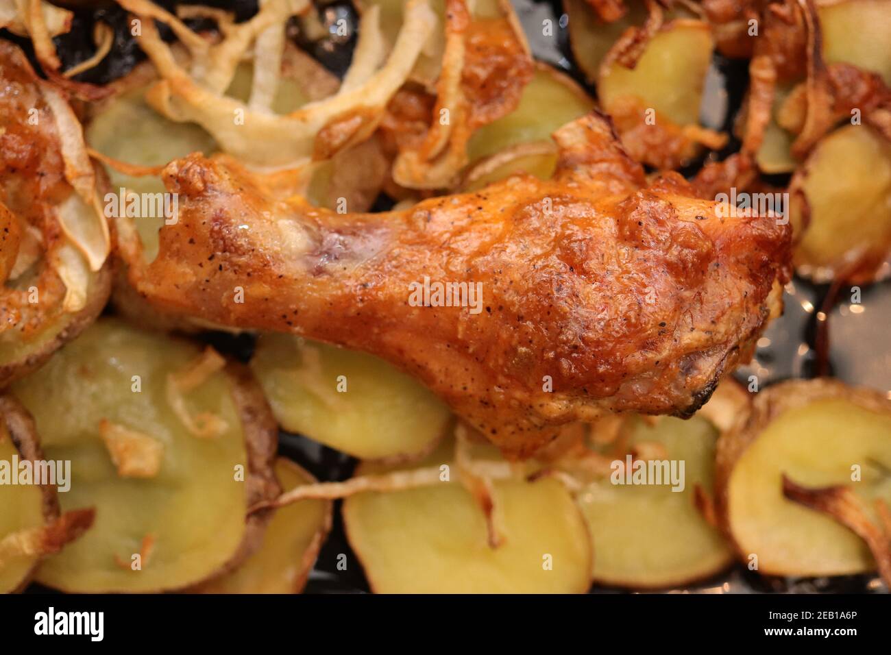 Fried chicken legs on potatoes and onions. Grilled lunch BBQ Stock
