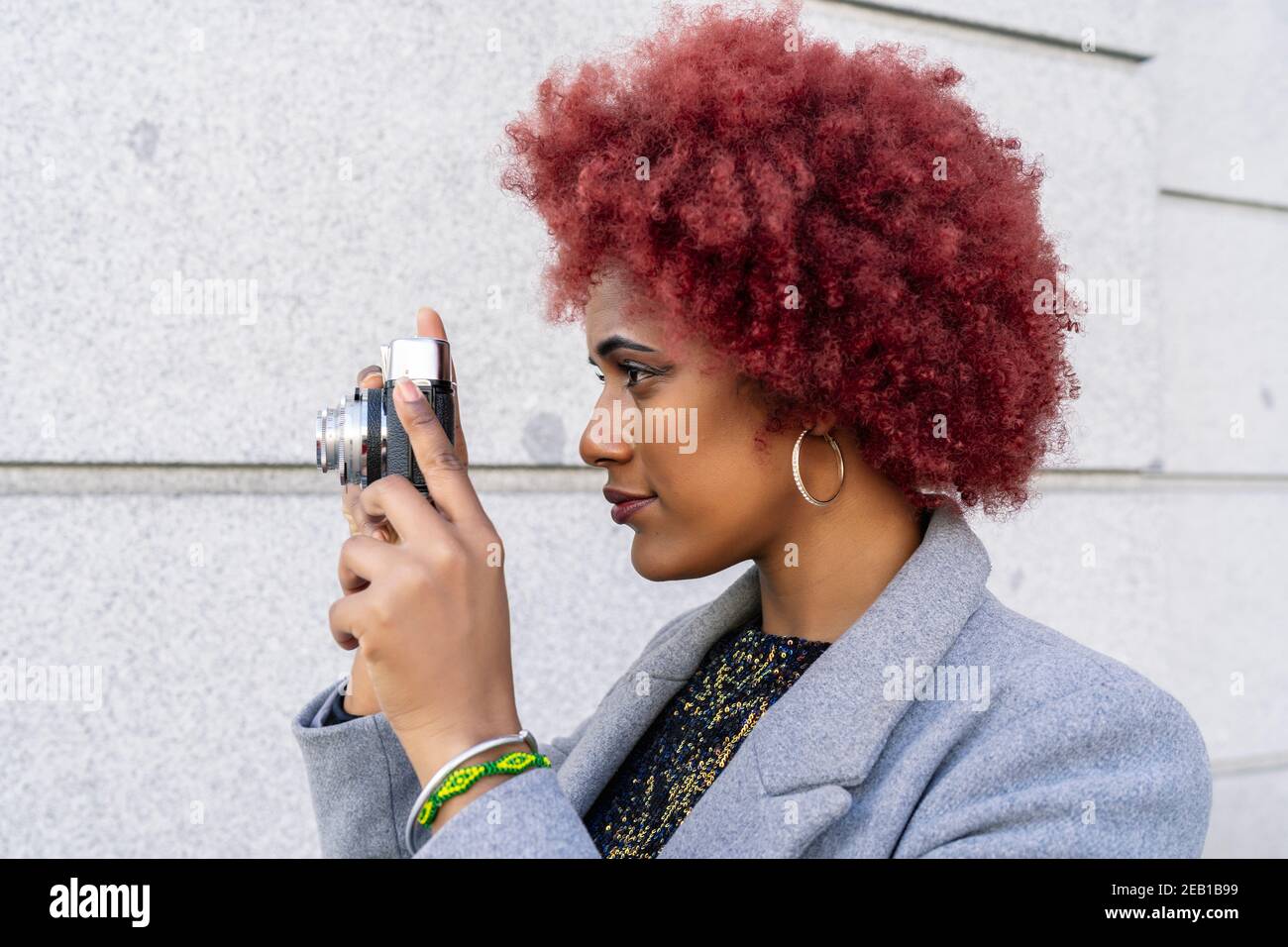 beautiful woman with afro hair taking pictures with her old camera Stock  Photo - Alamy