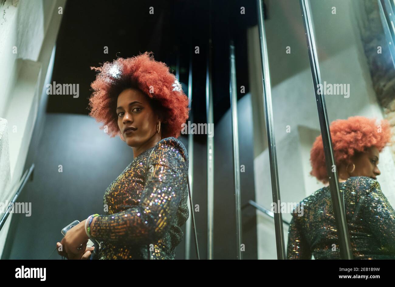 beautiful woman with afro hair reflected in the mirror Stock Photo