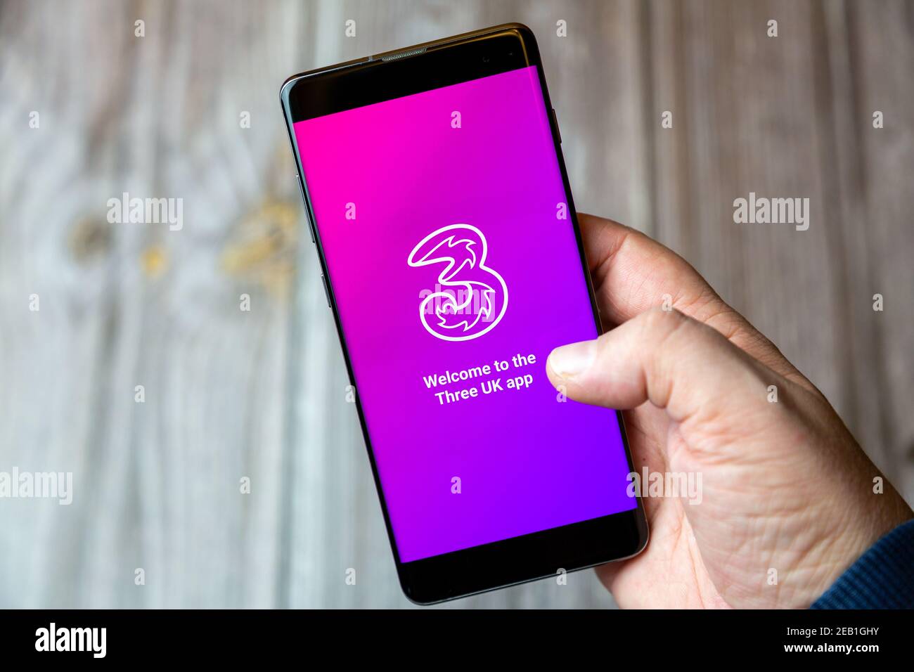 A mobile phone or cell phone being held by a hand with the 3 Mobile app