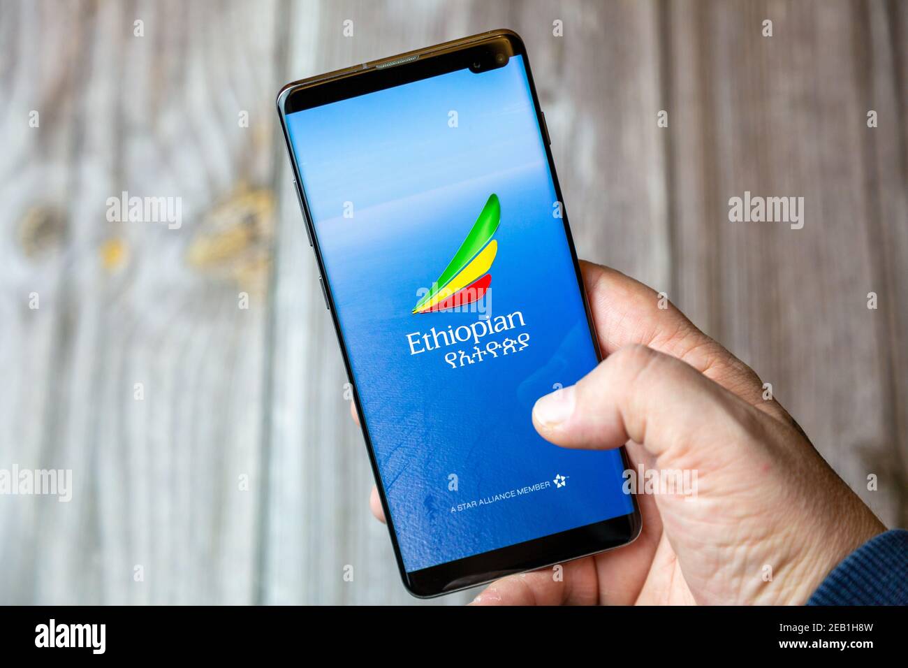 A mobile phone or cell phone being held by a hand with the ethiopian airlines app open on screen Stock Photo