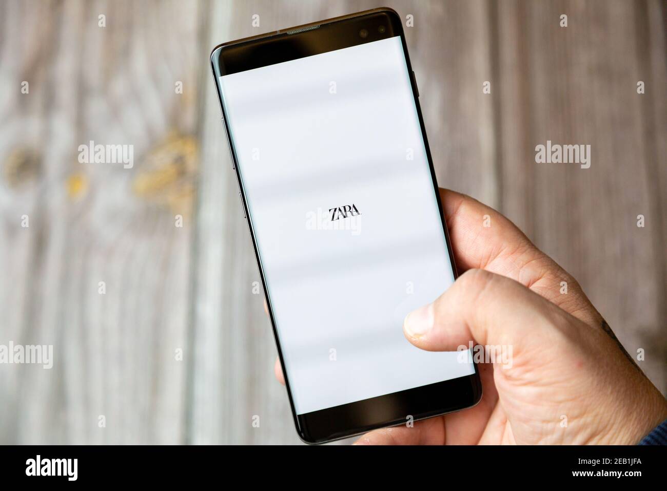 A mobile phone or cell phone being held by a hand with the Zara app open on  screen Stock Photo - Alamy