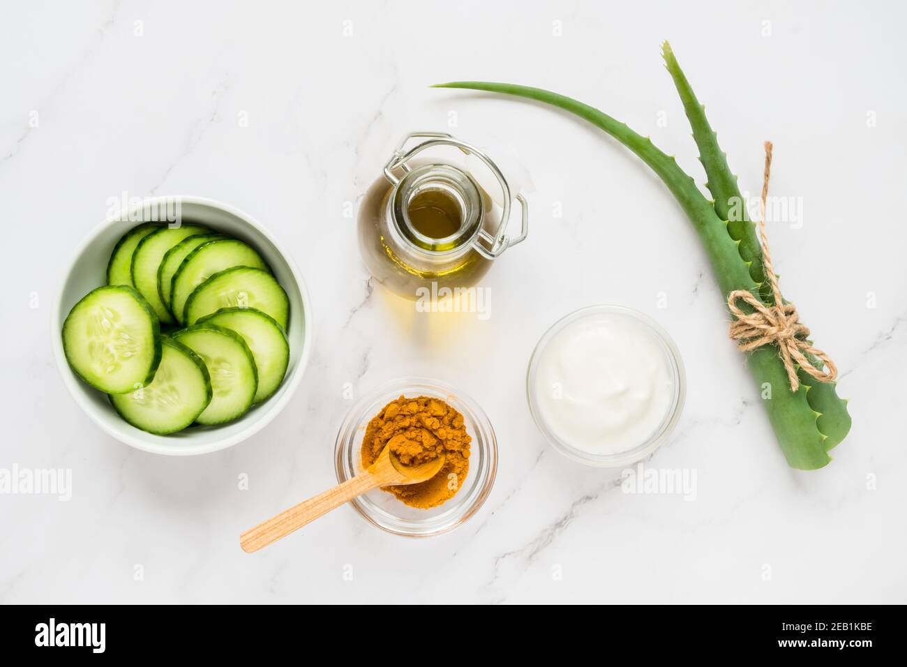 Homemade skin care concept. Green natural ingredients aloe vera, lemon, yogurt, turmeric, cucumber for making a cosmetic mask on a light background Stock Photo