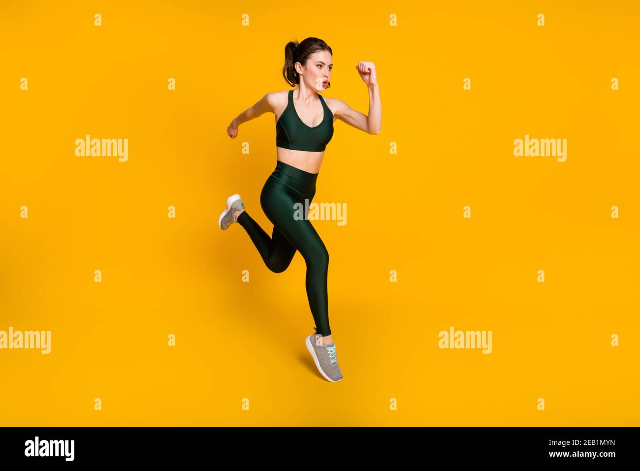 Full length photo of sportive lady running jogging cardio wear sports suit shoes isolated yellow color background Stock Photo