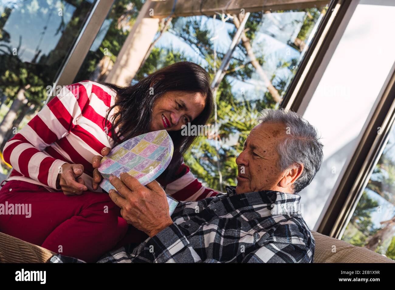 Happy old interracial couple at Valentines day with gifts Stock Photo