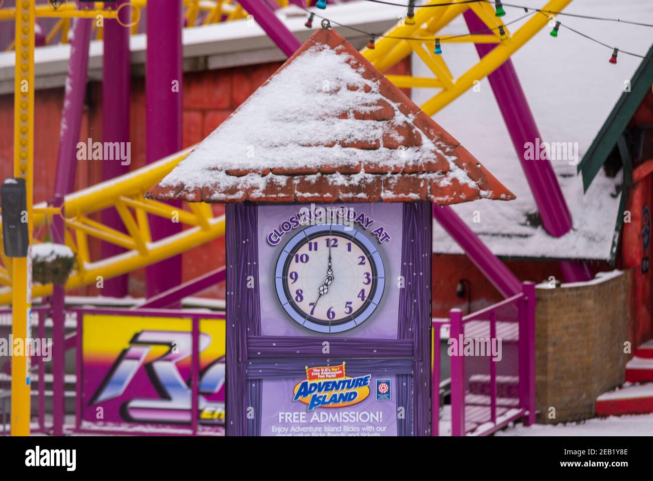 Closing time clock in Adventure Island theme park in Southend on Sea, Essex, UK, with snow from Storm Darcy. Stock Photo