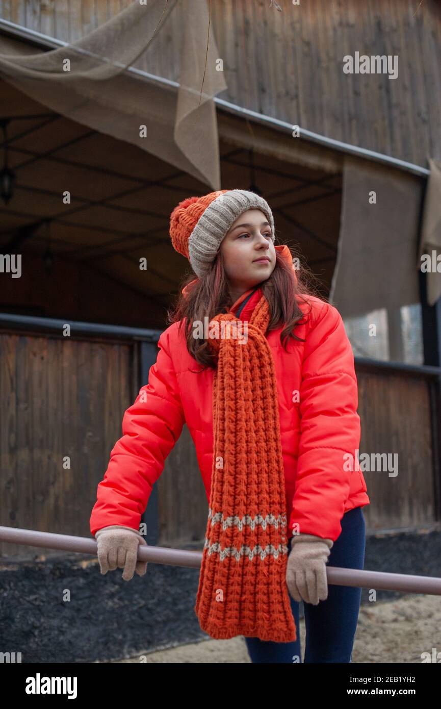 Girl in winter clothes. Girl 10 years old. Teenager in orange