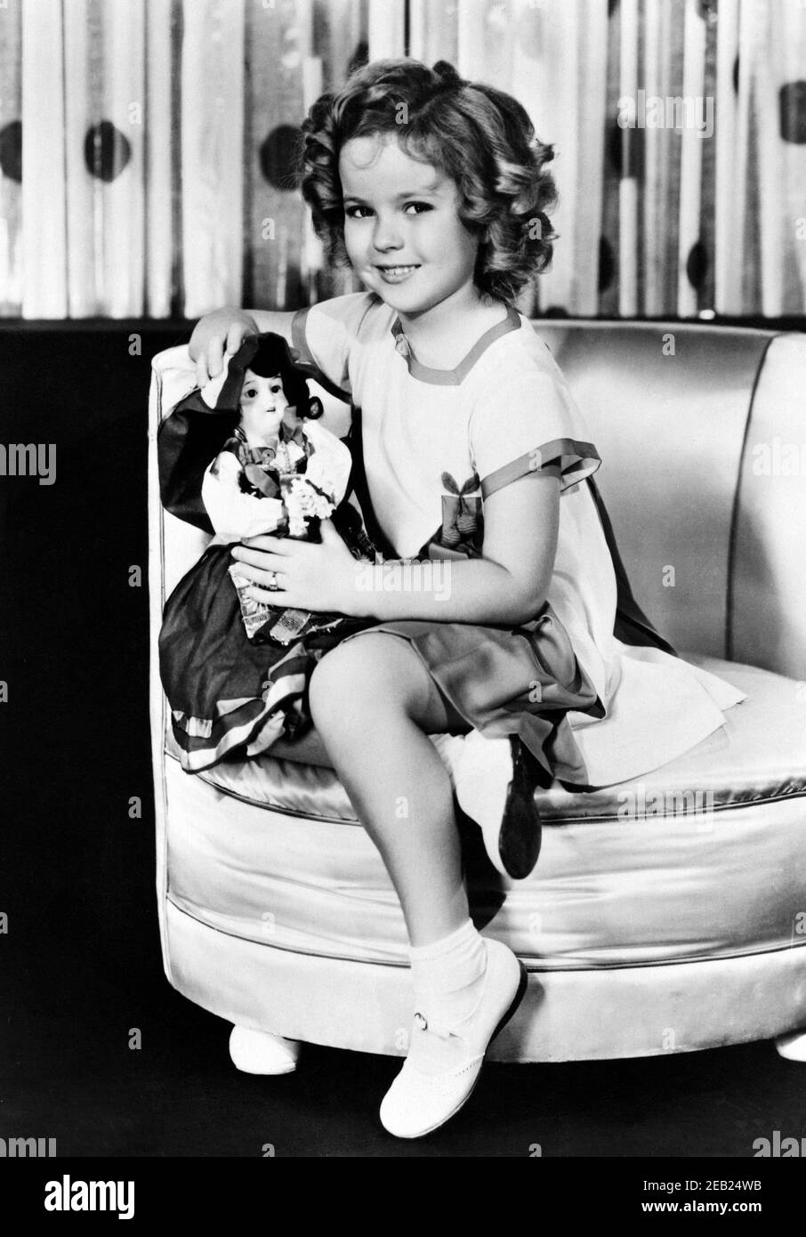1934 ca., USA  : The child actress  SHIRLEY TEMPLE ( 1928 -  2014 ) with a doll , Fox movie pubblicity still   - MOVIE - FILM - CINEMA - portrait - ritratto  - boccoli - riccioli - curls   - bambino prodigio  -  bambola - bambole - giocattolo  - giocattoli -  celebrity celebrities actors actor actress personality personalities with dolls  - toy - toys  - celebrità attori attrici personalità con - smile - sorriso - shoes - scarpe alla bebè - pltrona   ----  Archivio GBB Stock Photo