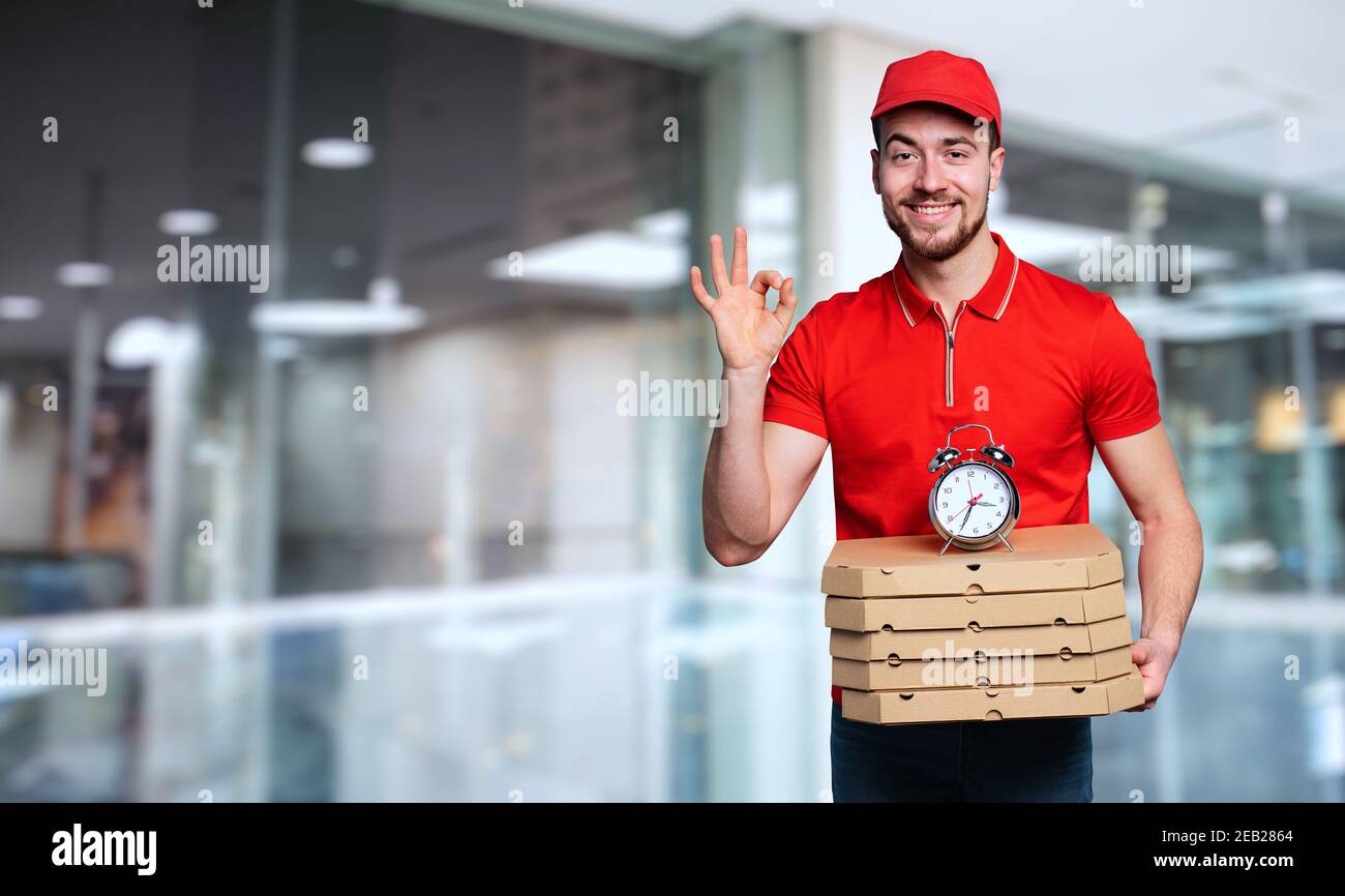 Courier is punctual to deliver quickly pizzas at home Stock Photo