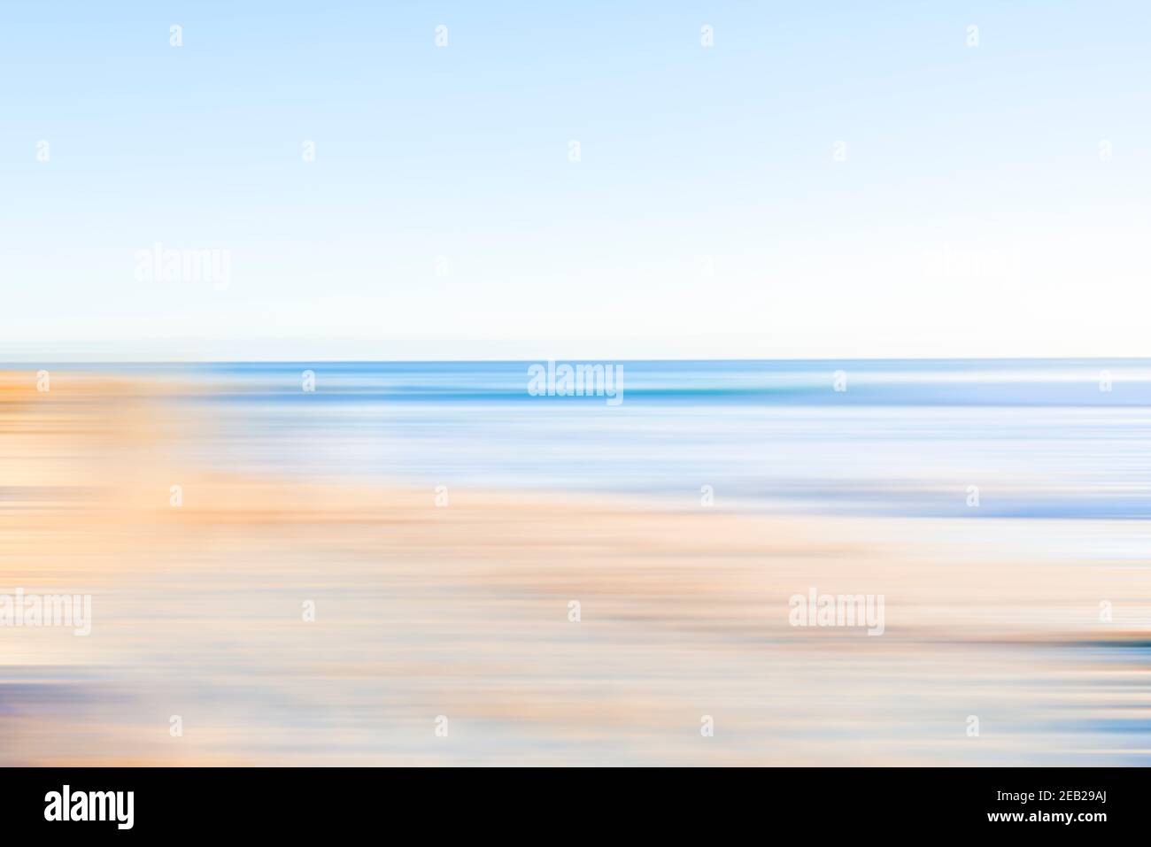 Coastal beachside blur in soft tones of blue and brown. Stock Photo