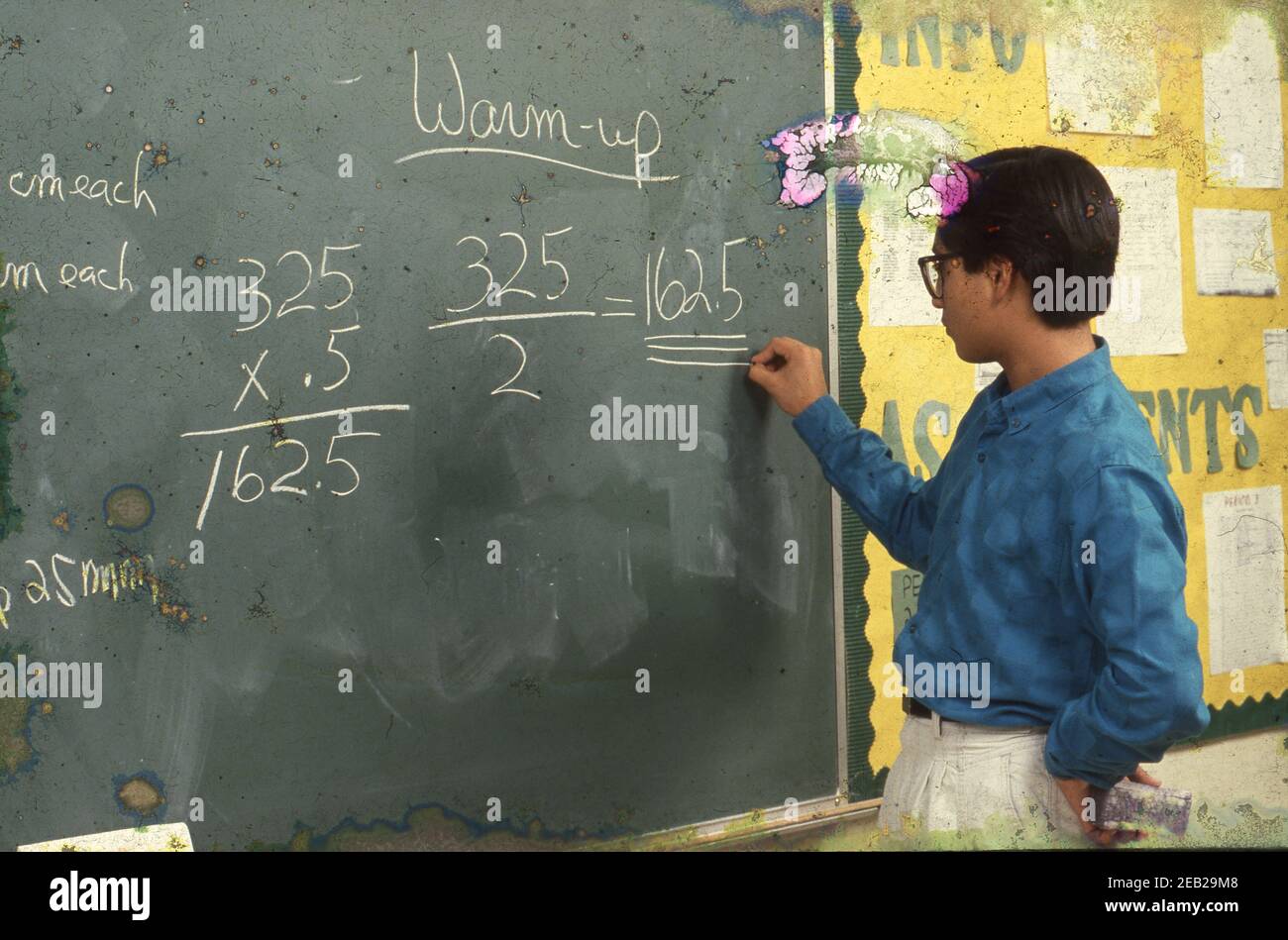 Austin, Texas USA: Male Hispanic high school student works out a math problem on a blackboard during class. ©1989 Bob Daemmrich  Model Release RE-046    BAD6814C Stock Photo