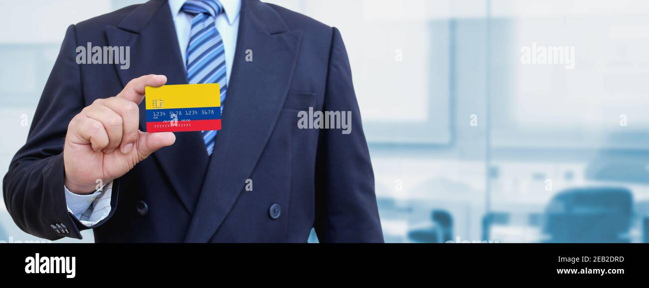 Cropped image of businessman holding plastic credit card with printed flag of Colombia. Background blurred. Stock Photo