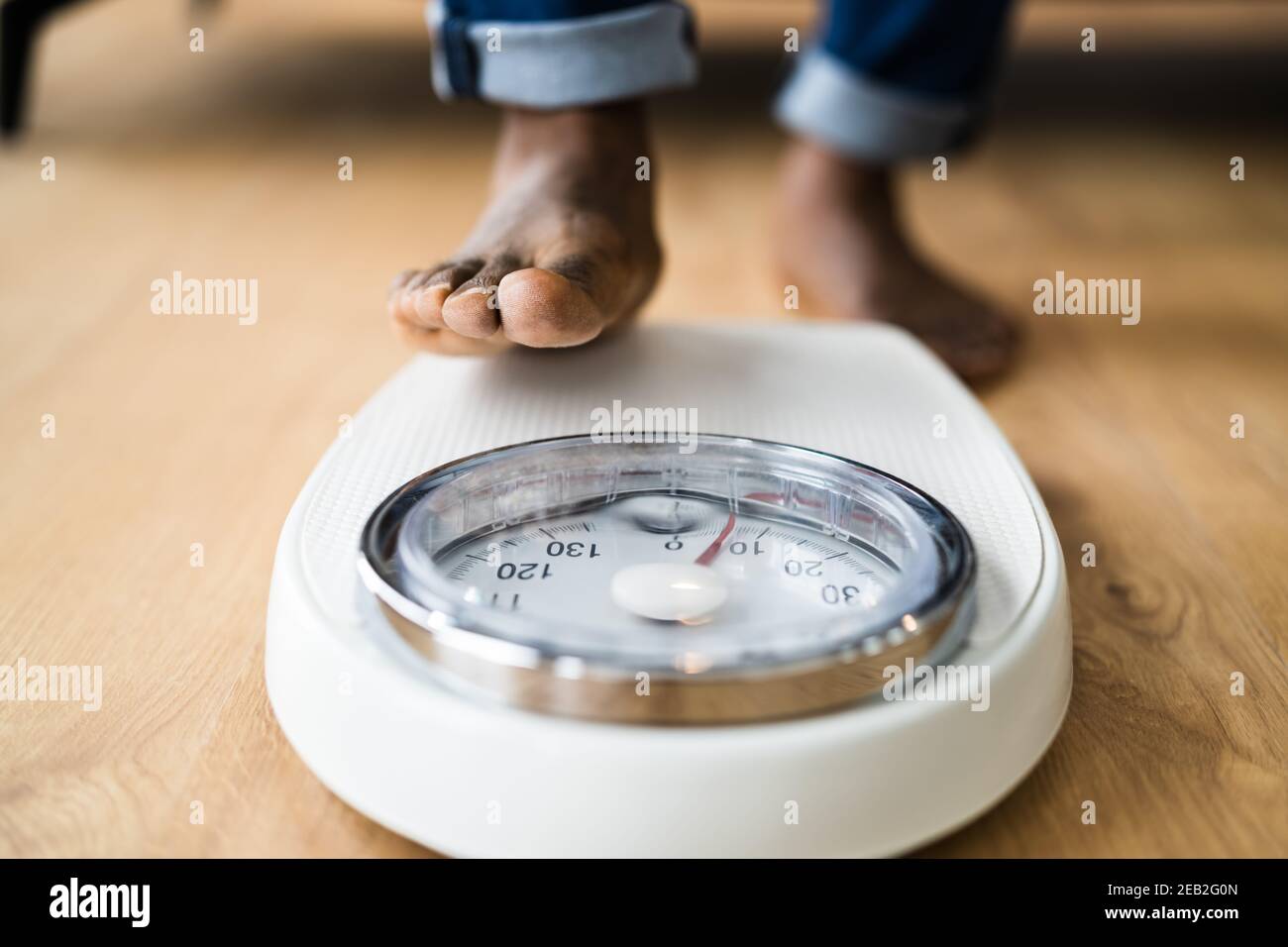 https://c8.alamy.com/comp/2EB2G0N/african-man-feet-standing-on-weight-scale-low-section-2EB2G0N.jpg