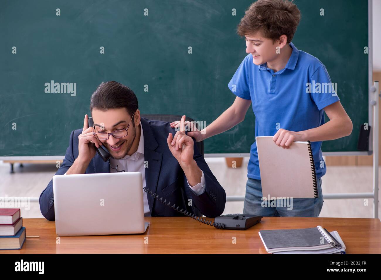 Male teacher and schoolboy in the classroom Stock Photo - Alamy