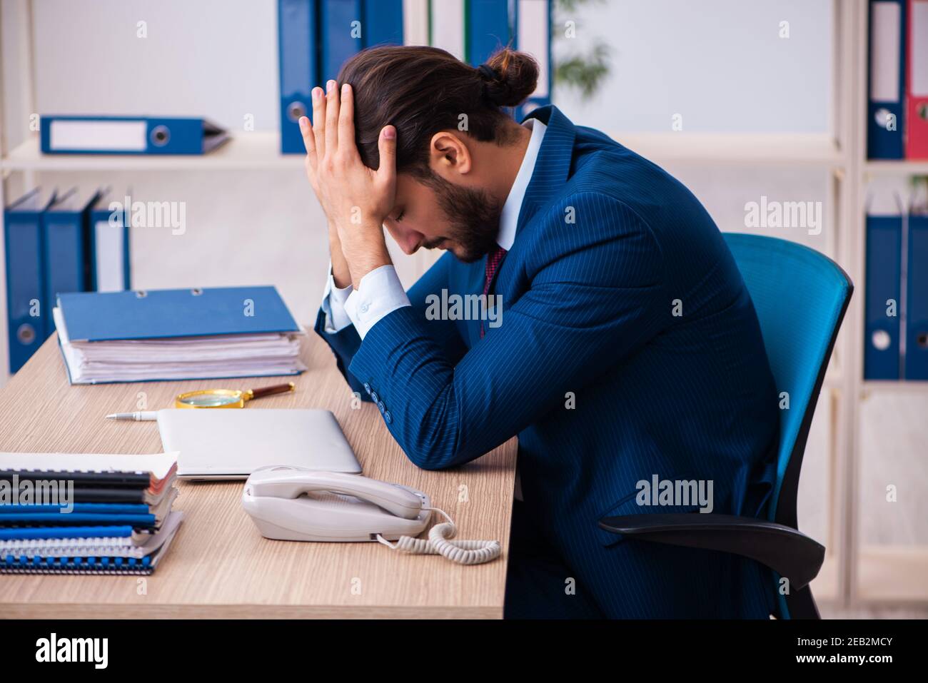 Young employee and too many work in the office Stock Photo - Alamy
