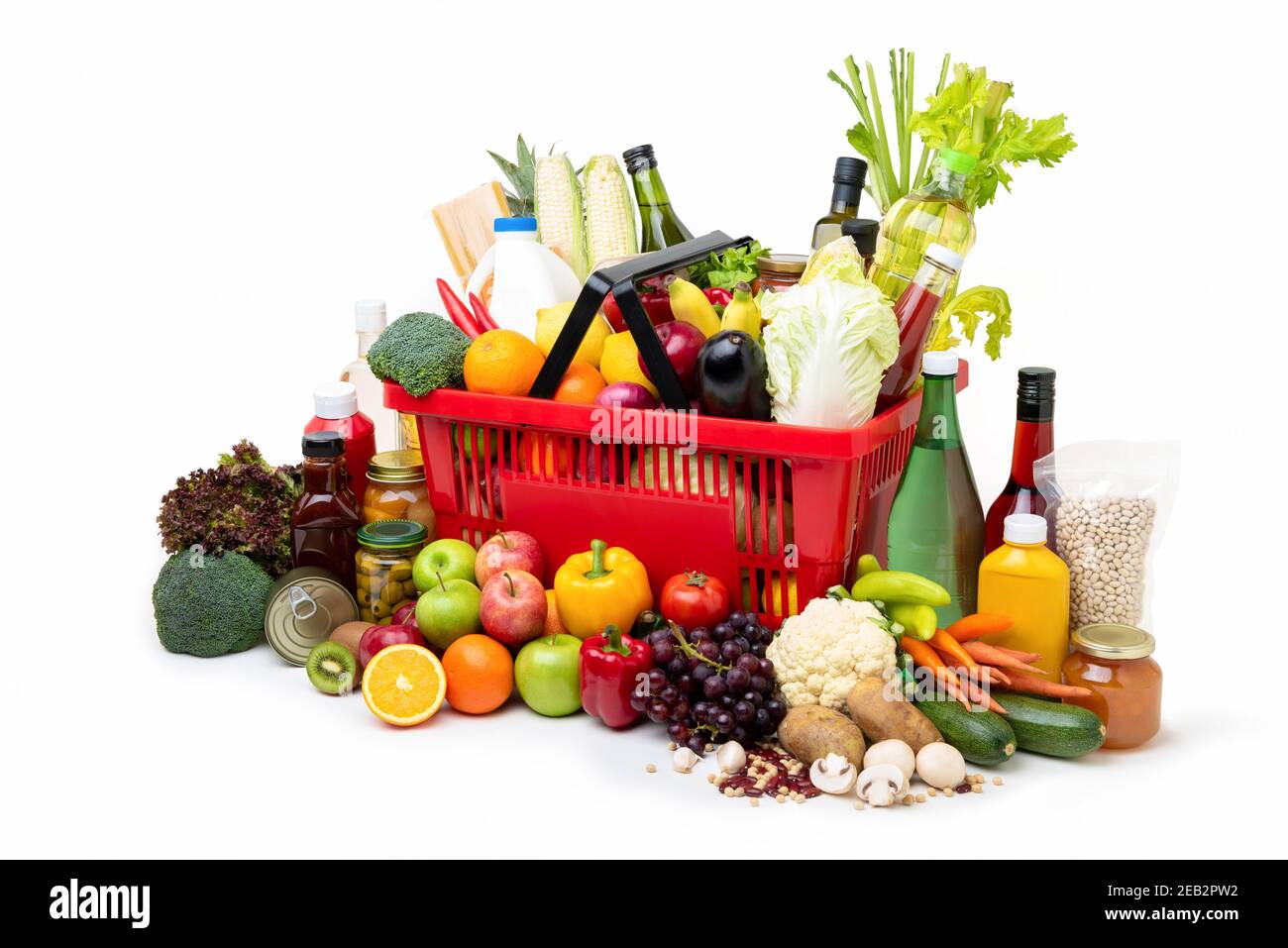 Red supermarket shopping basket full of  fresh organic colorful foods and groceries with assorted ingredients on white background Stock Photo