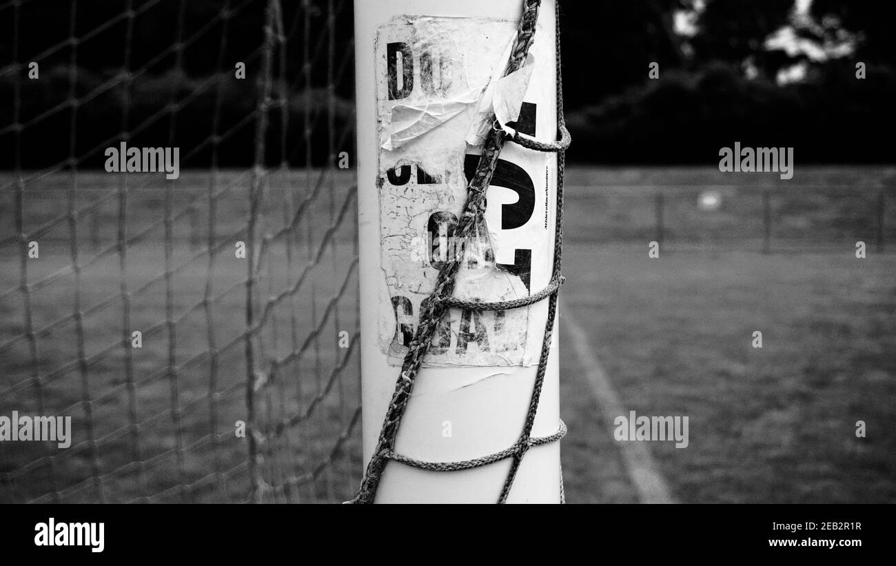 https://c8.alamy.com/comp/2EB2R1R/outdoor-white-soccer-goal-frame-and-twine-mesh-game-netting-empty-goalie-box-worn-weather-sticker-on-white-post-2EB2R1R.jpg