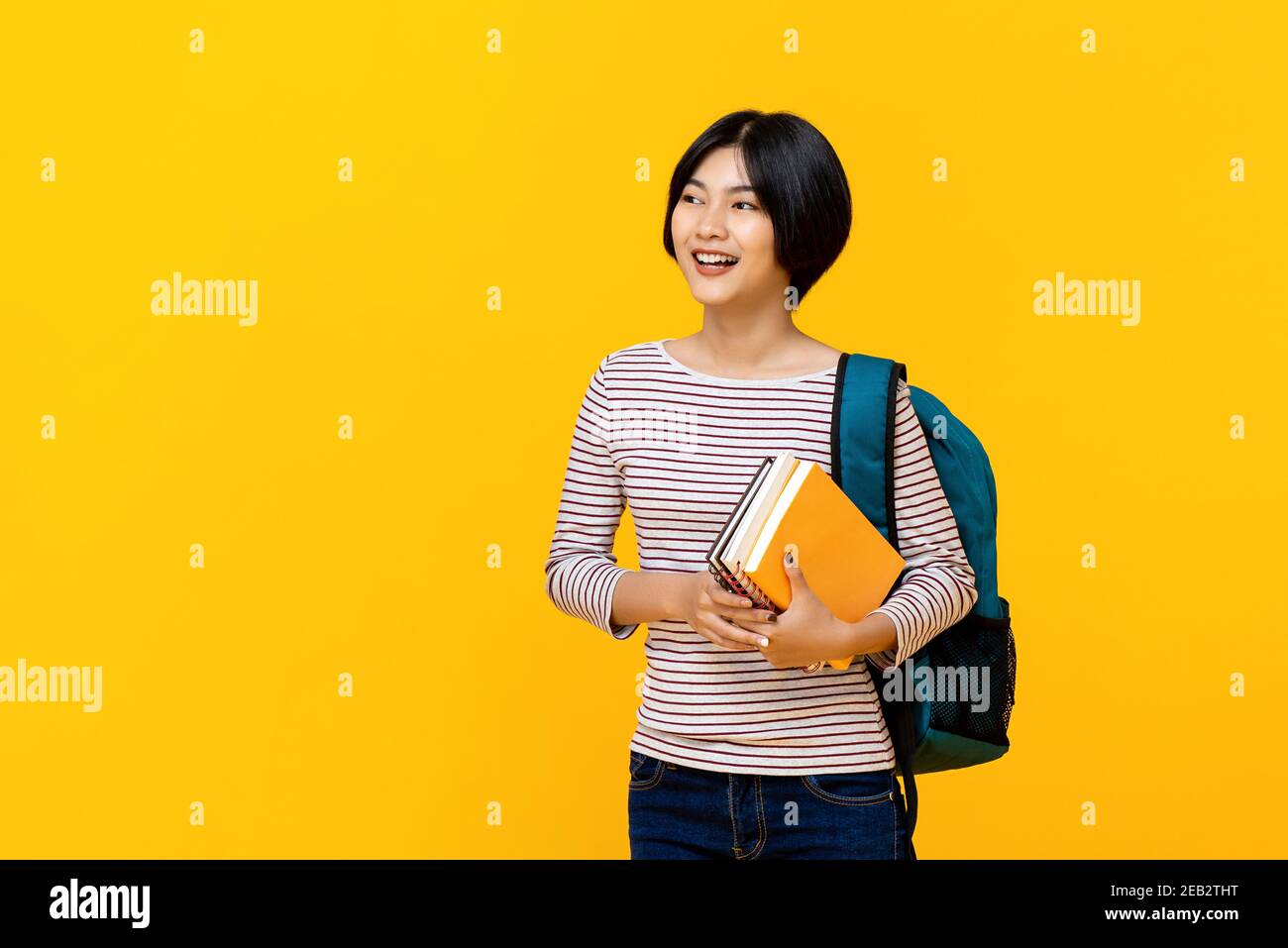 Young smiling Asian woman college student with backpack holding books ...