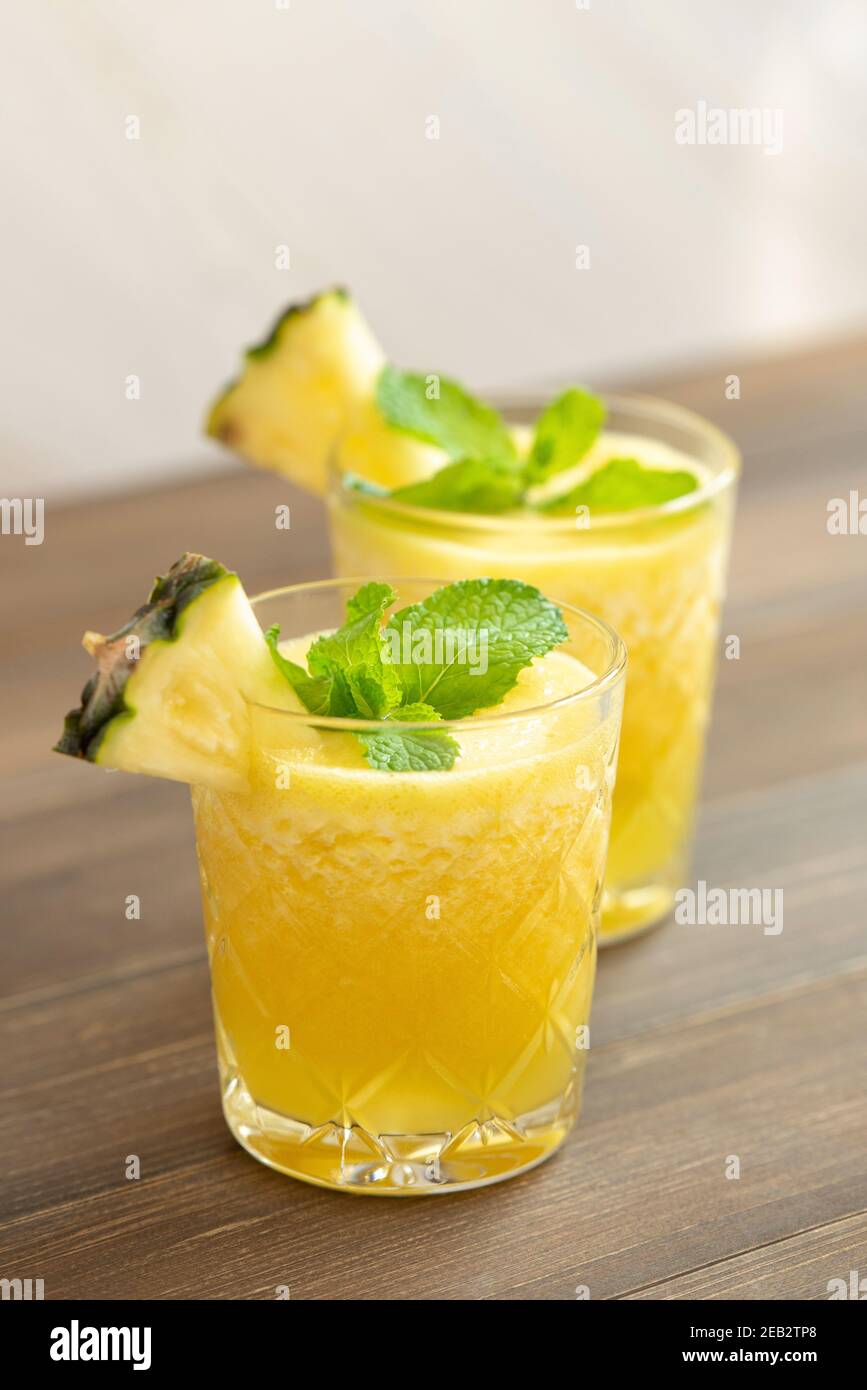 Refreshing healthy pineapple fruit smoothie drinks on wood table Stock Photo