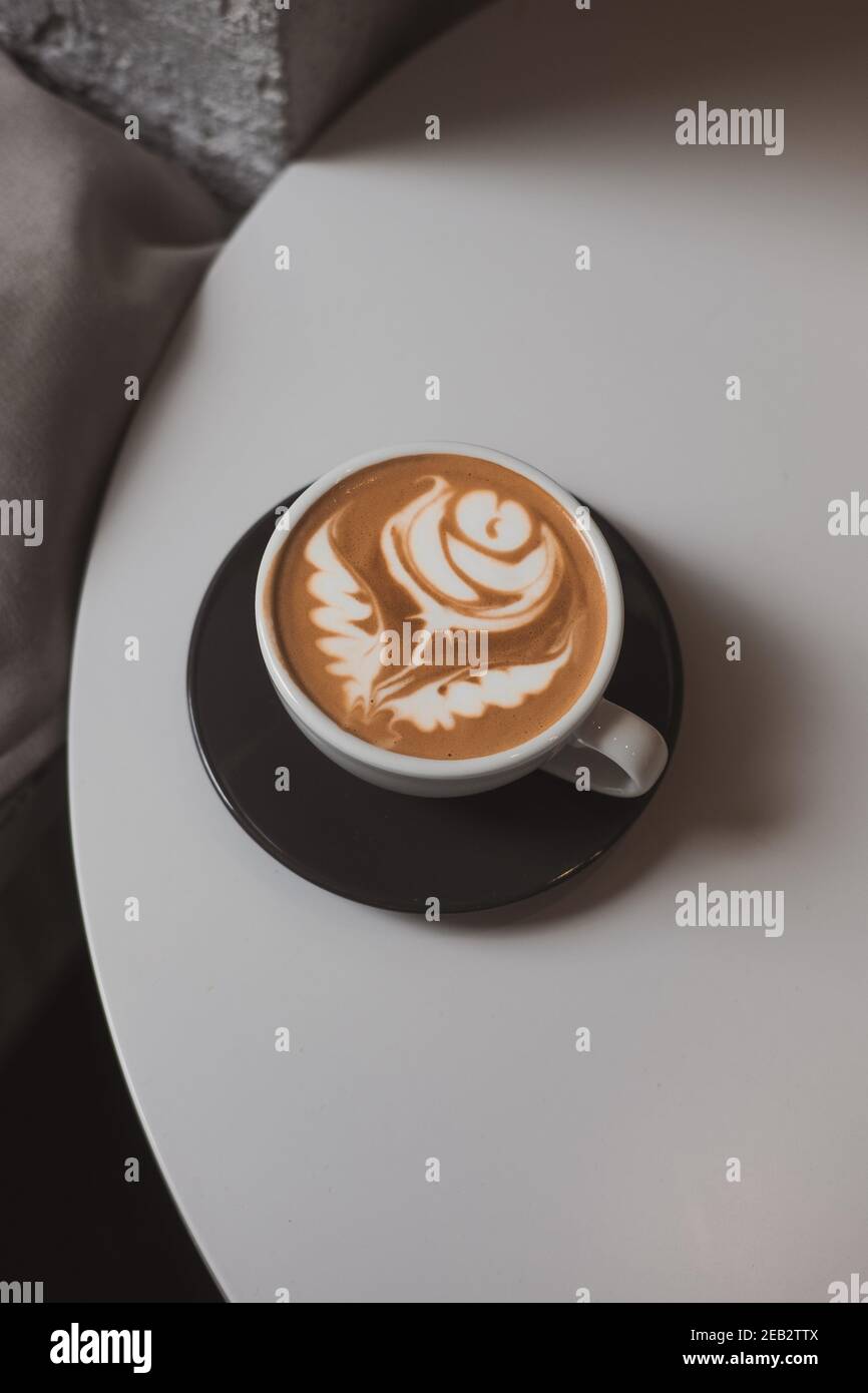 https://c8.alamy.com/comp/2EB2TTX/flat-white-coffee-flower-latte-art-on-white-table-hipster-coffee-shop-concept-minimalist-background-copy-space-from-above-2EB2TTX.jpg