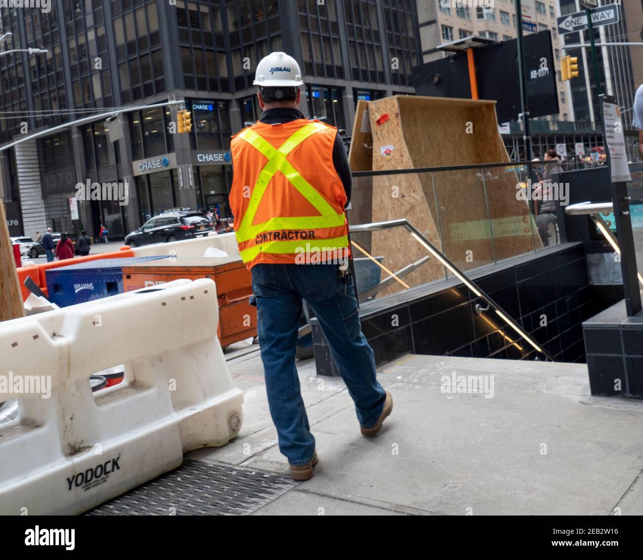 A male construction worker in safety vest and hardhat works in Manhattan New York. Stock Photo