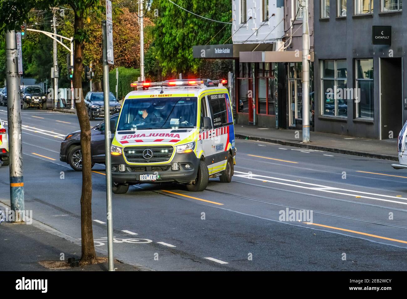 An ambulance with the offender is seen leaving the crime scene along the High Street An incident in Melbourne's inner suburb Prahran triggered a major police response involving Special Operation Group and a dozen of police officers, responding to a young man hurling stones onto the road from awing of an apartment building. A damage of property and street covered with stones and debris stopped Thursday morning traffic for an hour and a half. After a long negotiation with the police the offender gave himself up to the police and he was taken by ambulance to treat his cuts and other injuries. Stock Photo
