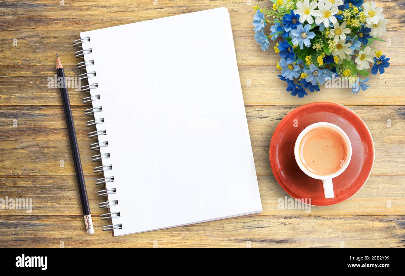 Top view image of blank notebook and cup of coffee on wooden table background Stock Photo