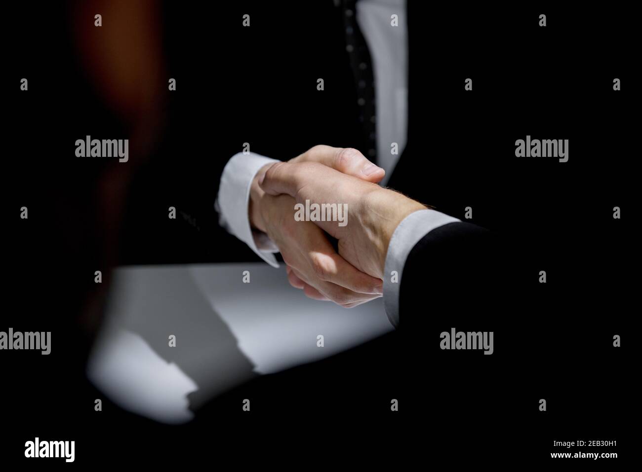 Anonymous business partners making handshake in confidential meeting Stock Photo