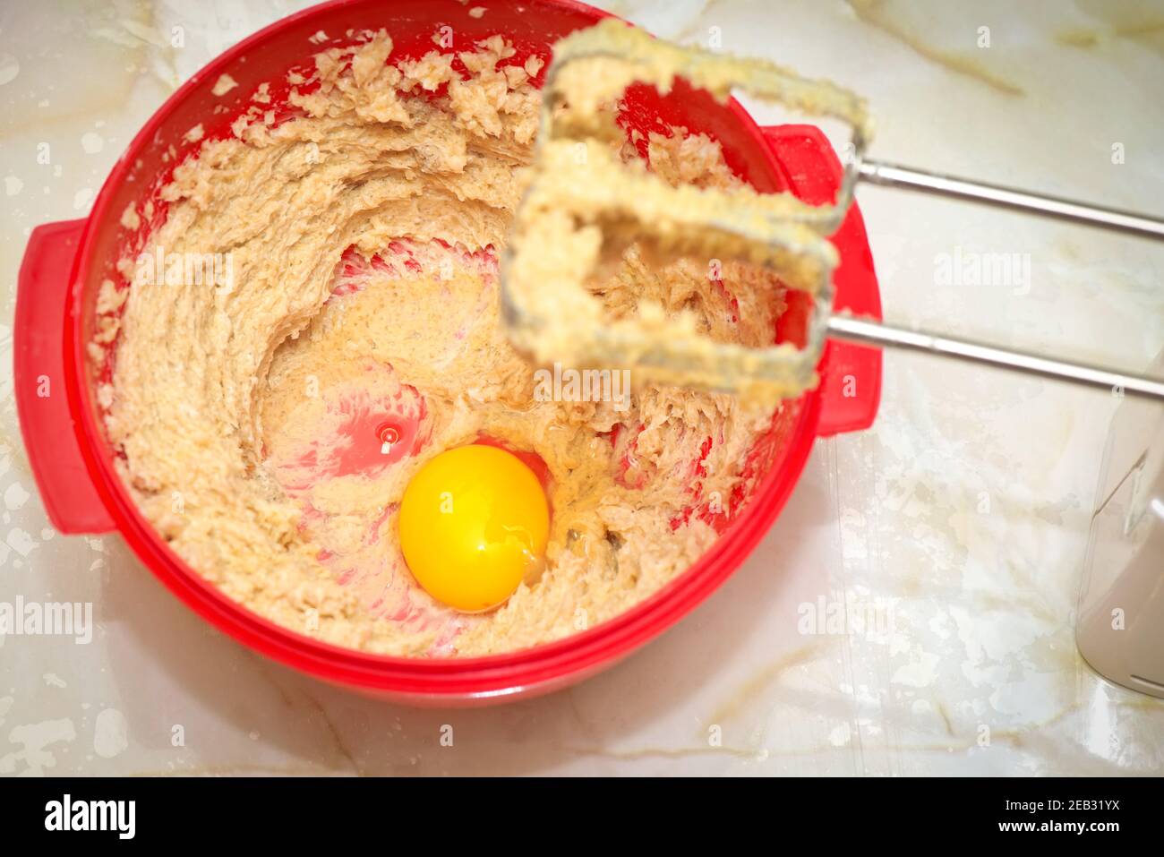 Red bowl with egg yolk and dough Stock Photo