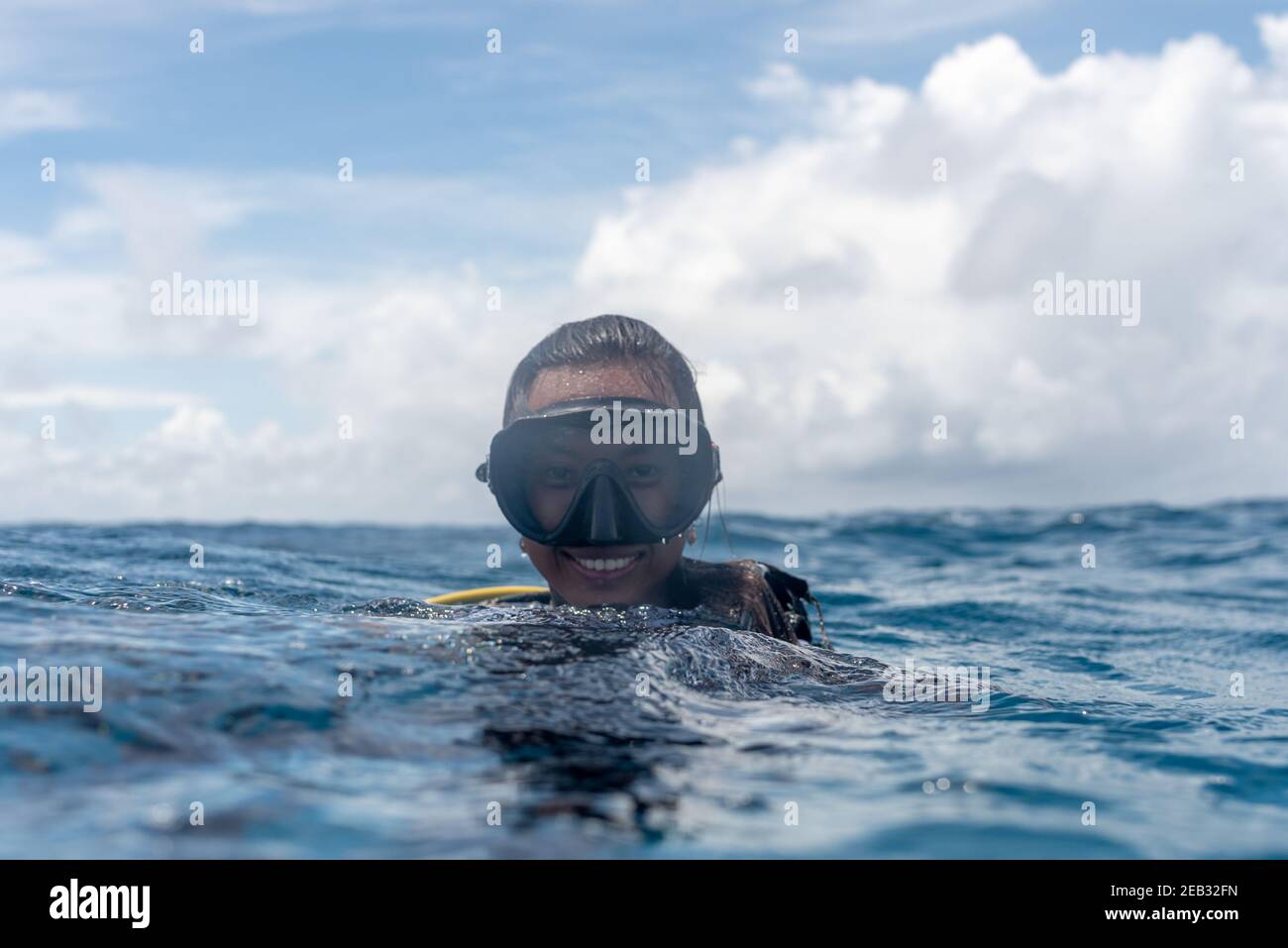 Scuba diving girl in blue ocean open water and blue sky Stock Photo