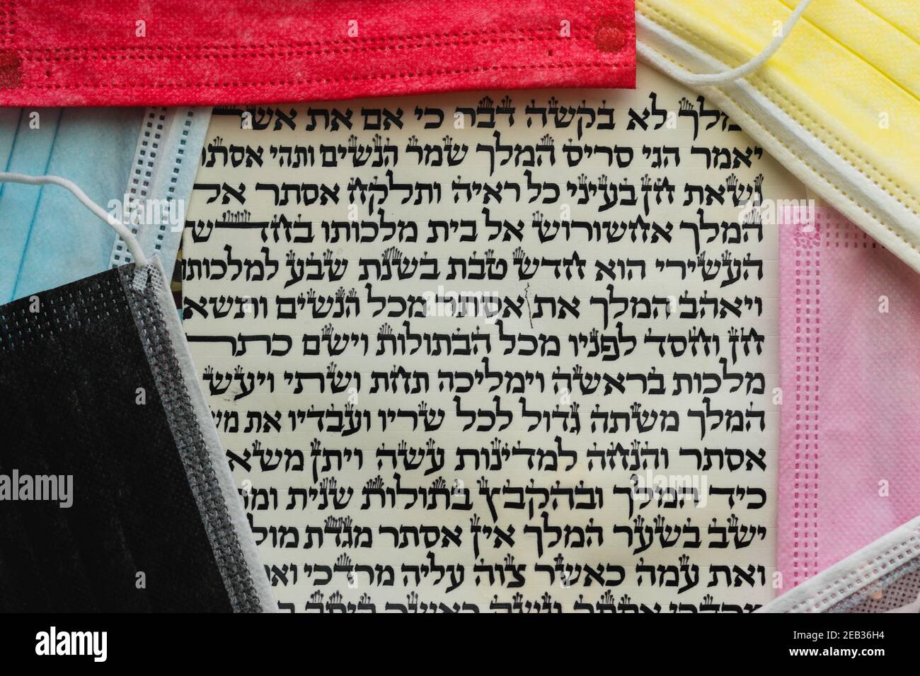 jerusalem-israel. 08-02-2021. The Book of Esther is written in Hebrew on parchment next to colored surgical masks to prevent infection with the corona Stock Photo