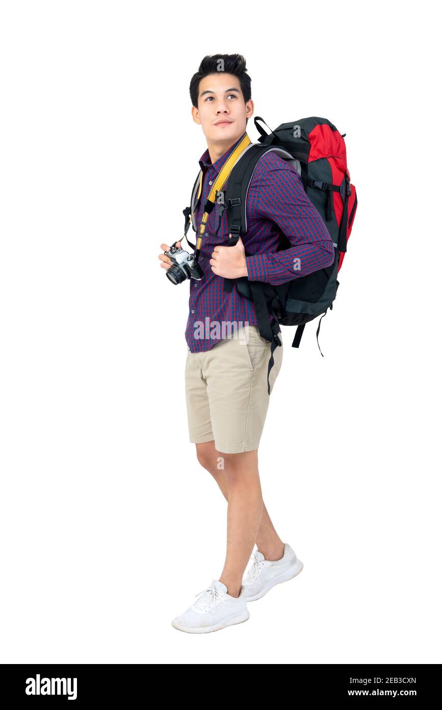 Isolated Portrait of handsome young attractive asian tourist man in casual attire carrying backpack and camera, studio shot white background Stock Photo