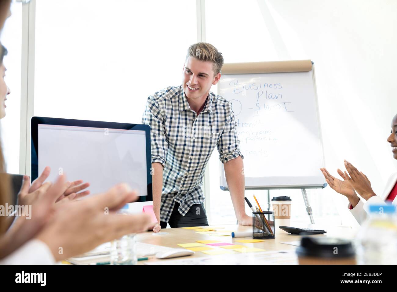 Successful casual businessman being congratulated by his colleagues in a board room meeting Stock Photo