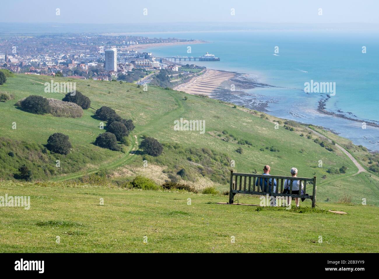 Senior couple seated on bench enjoy views over Eastbourne, Sussex, England, GB, UK Stock Photo