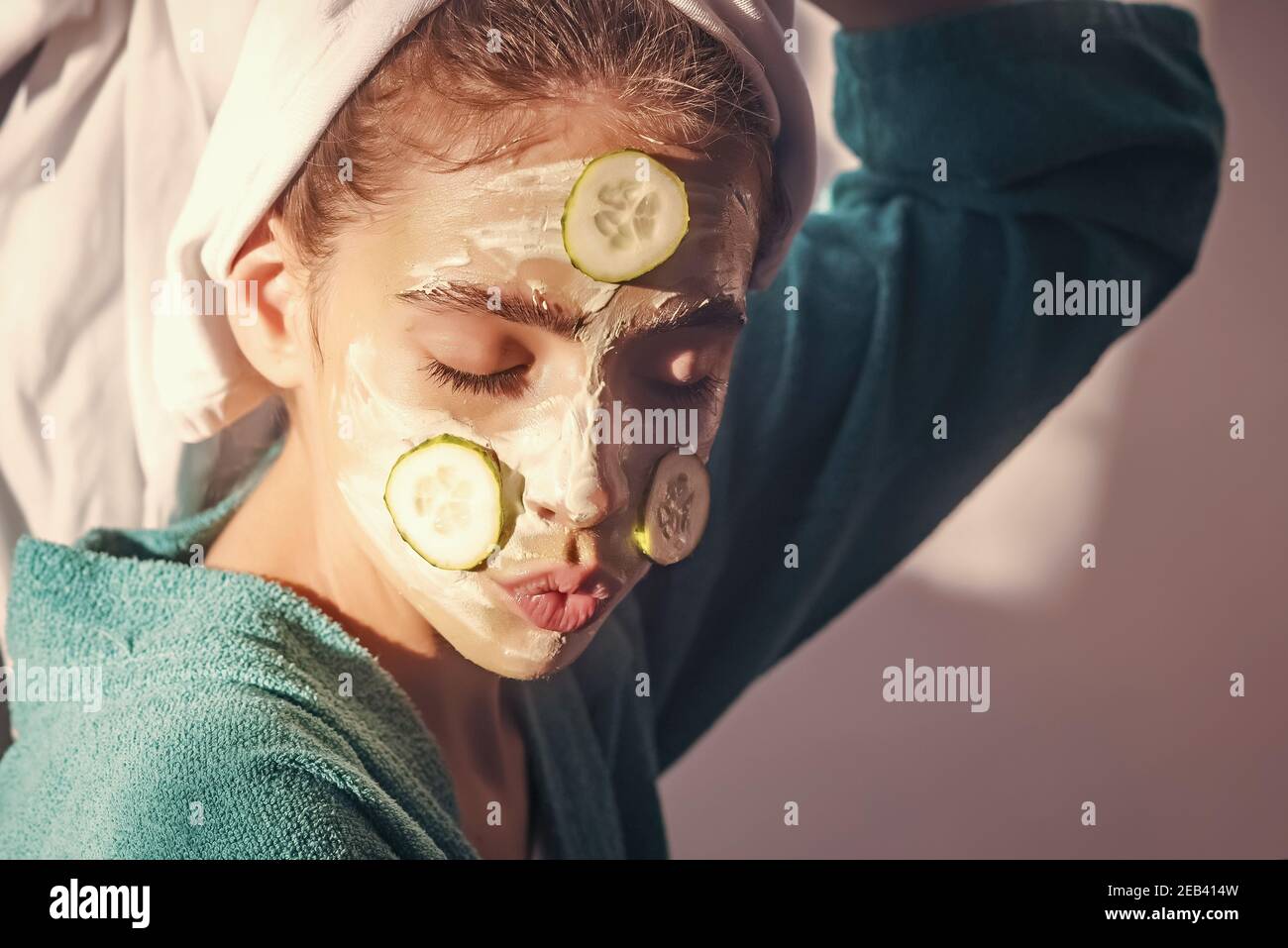 Girl or woman face with cucumber mask, towel on head. Skin and hair